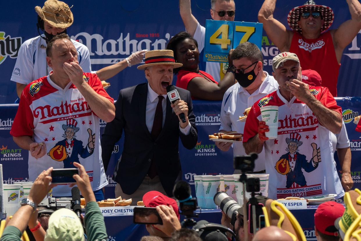 Competitive eaters Joey "Jaws" Chestnut (L), defending champion, and Geoffrey Esper (R), second-place winner, participate in the 2021 Nathan's Famous 4th Of July International Hot Dog Eating Contest on July 4, 2021, in New York City.