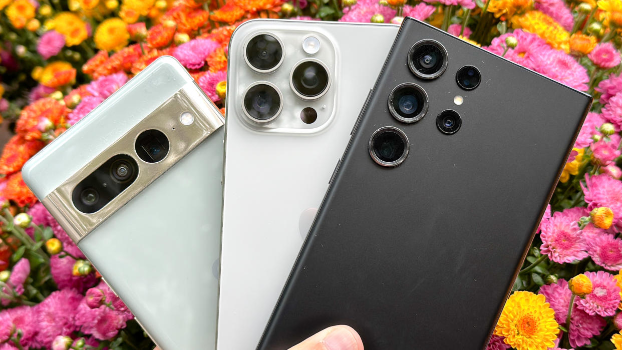  Google Pixel 7 Pro, iPhone 15 Pro Max and Galaxy S23 Ultra camera shown held in one hand. 