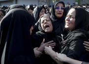Families of victims of Saturday's terror attack on a military parade in the southwestern city of Ahvaz, that killed 25 people mourn at a mass funeral ceremony, in Ahvaz, Iran, Monday, Sept. 24, 2018. Thousands gathered at the Sarallah Mosque on Ahvaz's Taleghani junction, carrying caskets in the sweltering heat. (AP Photo/Ebrahim Noroozi)