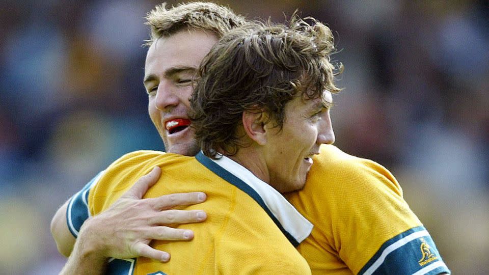 Chris Latham is congratulated by his teammate Mat Rogers during the victory over Namibia. - Christophe Simon/AFP/Getty Images