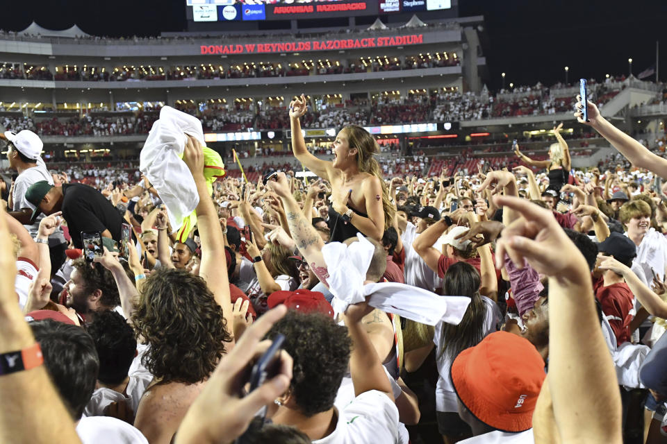 Arkansas fans rush the field to celebrate Arkansas' win over Texas during an NCAA college football game Saturday, Sept. 11, 2021, in Fayetteville, Ark. (AP Photo/Michael Woods)