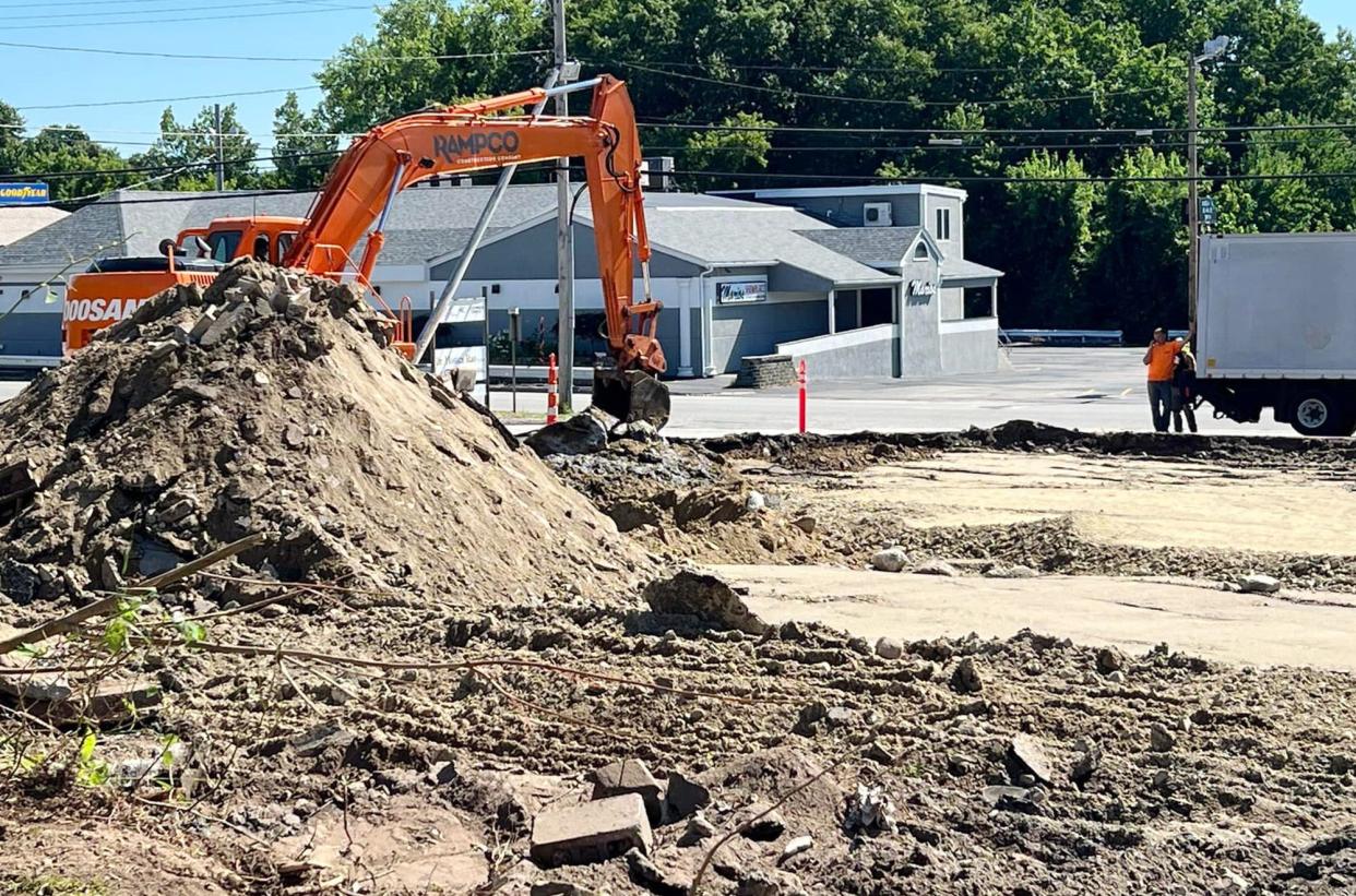 Construction workers do the finishing touches Tuesday of cleaning the property of the Wind Tiki restaurant, which was destroyed by a raging arson fire March 18.