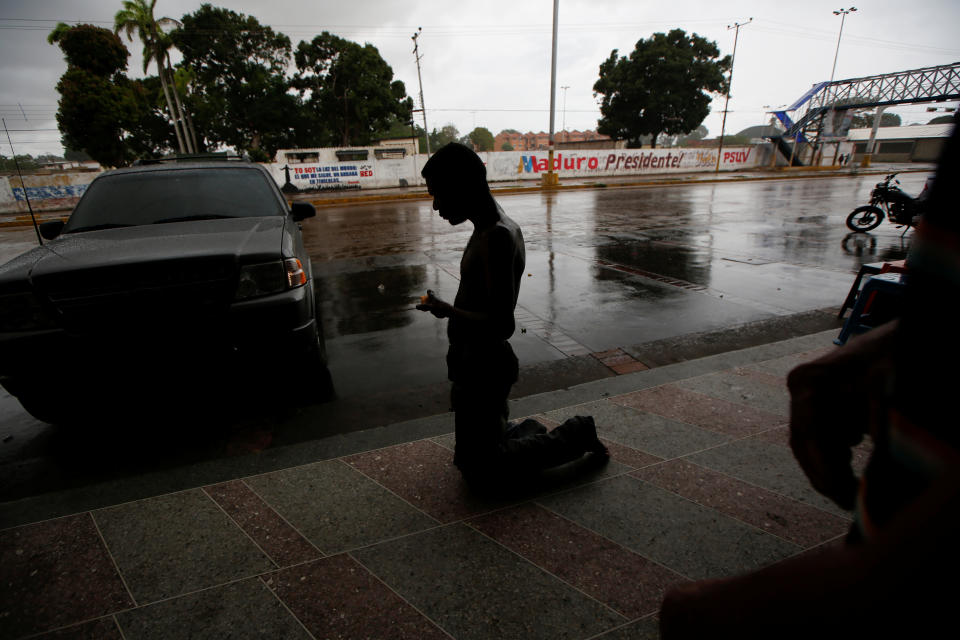 A homeless man kneels across from graffiti that reads "Maduro President," in El Tigre, Venezuela, on June 2. (Photo: Ivan Alvarado/Reuters)