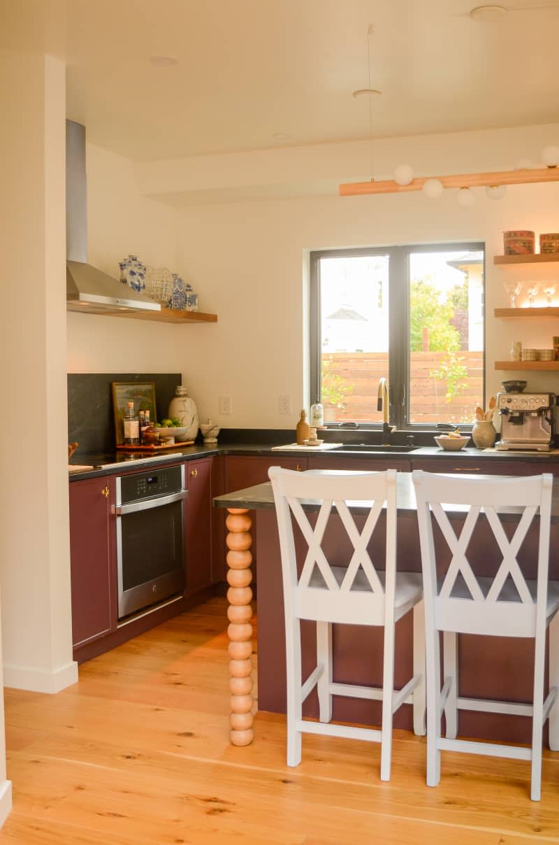 White barstools seen in neutral toned kitchen.