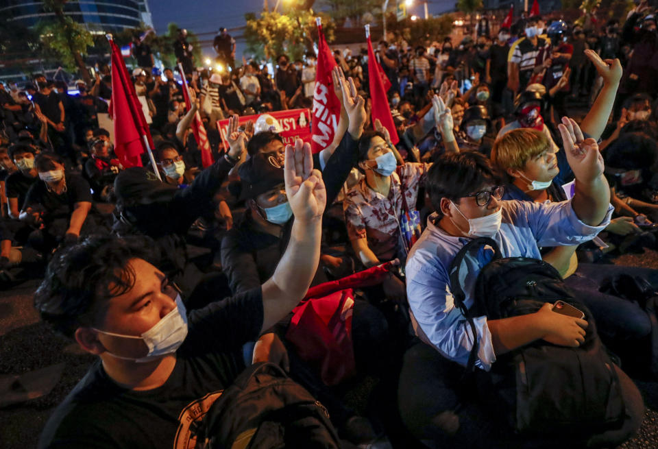 Anti-government protesters flash three-fingered salute, protest outside the Criminal court during a protest in Bangkok, Thailand, Saturday, March 6, 2021. A new faction of Thailand's student-led anti-government movement calling itself REDEM, short for Restart Democracy, announced plans to march to Bangkok's Criminal Court Saturday to highlight the plight of several detained leaders of the protest movement. (AP Photo/Sakchai Lalit)