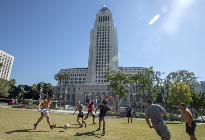 LOS ANGELES, CA - OCTOBER 14, 2021: Los Angeles City Hall on Spring St. in downtown Los Angeles is seen in the background as people play soccer at Grand Park. Los Angeles will officially require its city workers to be vaccinated against COVID-19 as the vaccination and reporting rules become "conditions of city employment," according to its ordinance. But it remains unclear what will happen to those who have refused to get the shots. (Mel Melcon / Los Angeles Times)