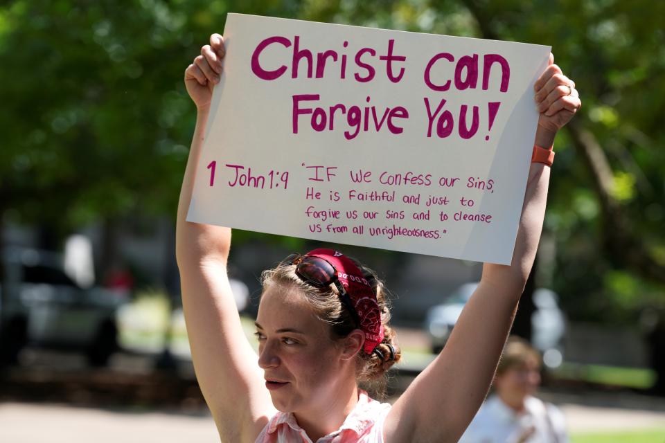 A woman supporting restrictions on abortion holds a sign outside the South Carolina Statehouse on Thursday, July 7, 2022, in Columbia, S.C. Protesters clashed outside a legislative building, where lawmakers were taking testimony as they consider new restrictions on abortion in the wake of the U.S. Supreme Court's decision overturning of Roe v. Wade. (AP Photo/Meg Kinnard)