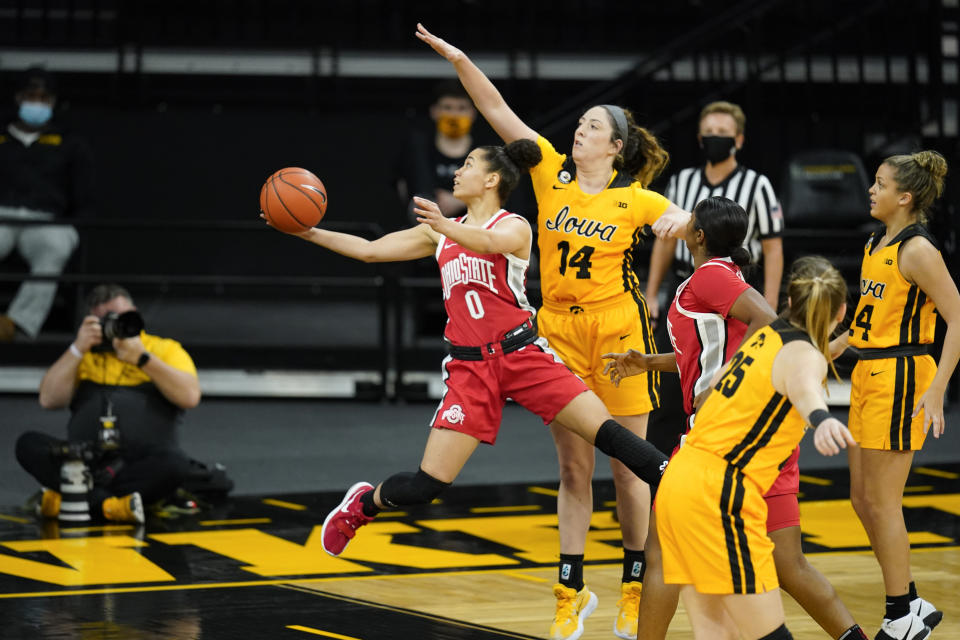 Ohio State guard Madison Greene (0) drives to the basket past Iowa guard McKenna Warnock (14) during the first half of an NCAA college basketball game, Wednesday, Jan. 13, 2021, in Iowa City, Iowa. (AP Photo/Charlie Neibergall)