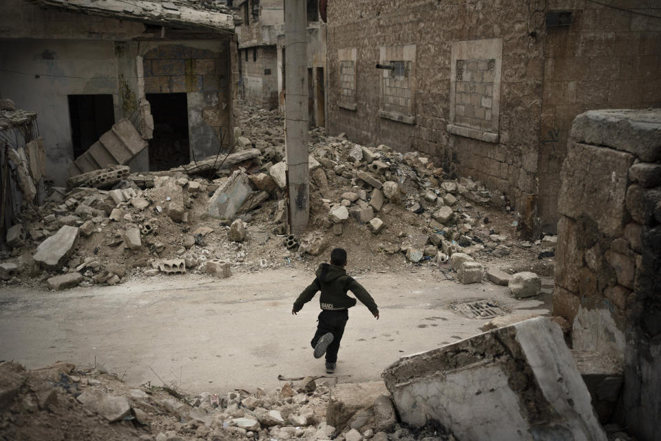 In this Thursday, March 12, 2020 photo, a boy plays in a neighborhood heavily damaged by airstrikes in Idlib, Syria. Idlib city is the last urban area still under opposition control in Syria, located in a shrinking rebel enclave in the northwestern province of the same name. Syria’s civil war, which entered its 10th year Monday, March 15, 2020, has shrunk in geographical scope -- focusing on this corner of the country -- but the misery wreaked by the conflict has not diminished. (AP Photo/Felipe Dana)