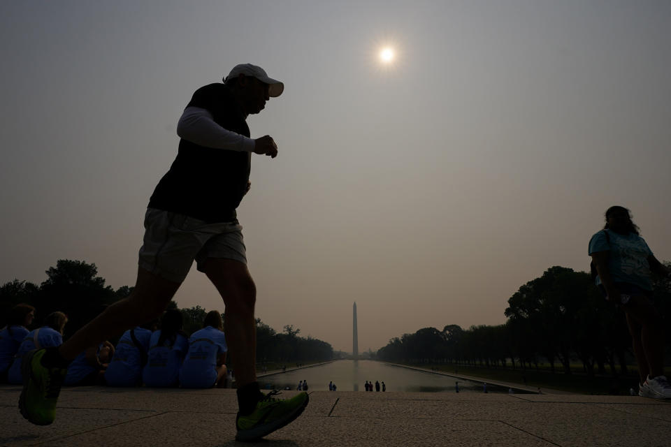 A jogger trots under haze over the Reflecting Pool in Washington, D.C., on June 7, 2023. (Julio Cortez / AP)