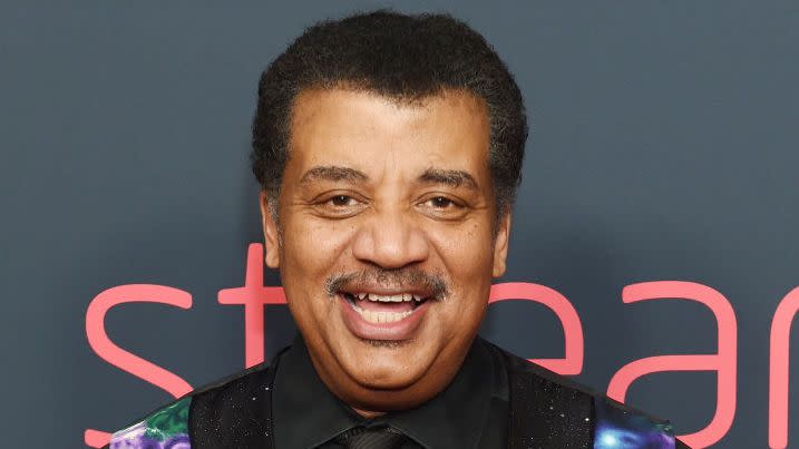 neil degrasse tyson smiling for a photo at an awards show red carpet