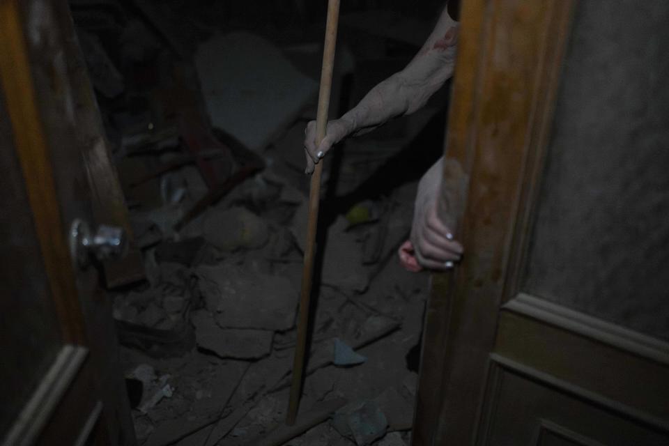 An elderly woman walks out of her apartment destroyed in Russian missile attacks in Odesa, Ukraine, Sunday, July 23, 2023. (AP Photo/Jae C. Hong)