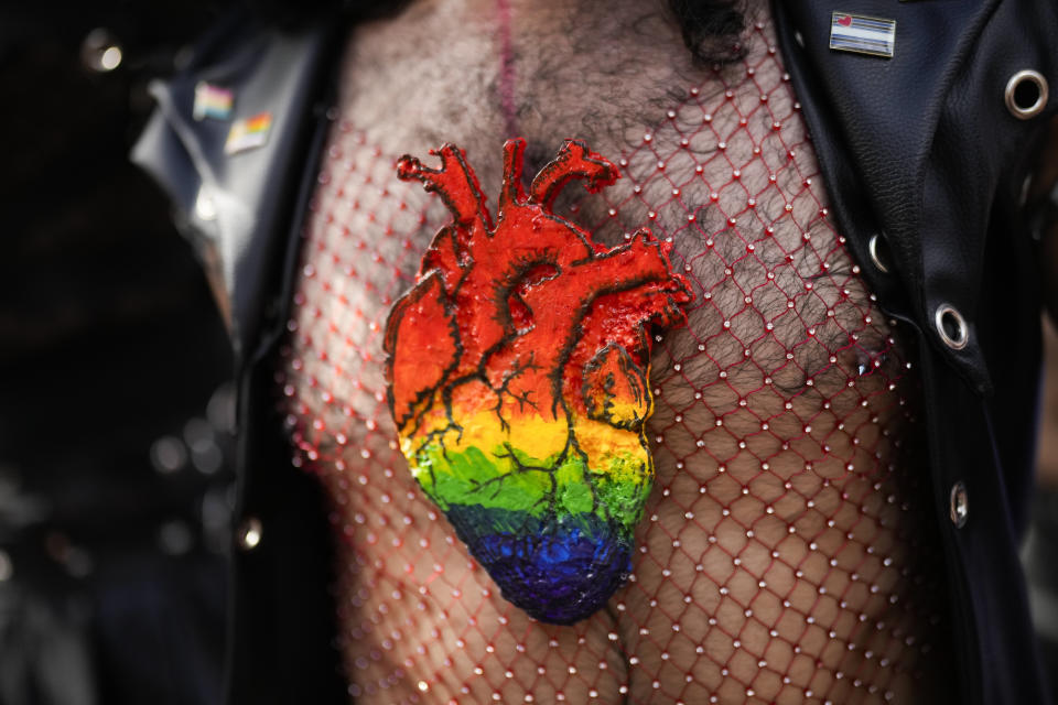 A reveler, wearing a rainbow-colored heart shape on his chest, takes part in a Pride parade marking the culmination of LGBTQ+ Pride month in Panama City, Saturday, June 29, 2024. (AP Photo/Matias Delacroix)