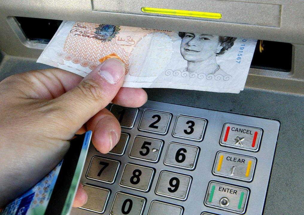 File photo dated 06/04/06 of a person using a cashpoint. Around £235 million is expected to be withdrawn from ATMs on Thursday as people fit trips to cash machines around casting their General Election votes, according to a forecast from UK cash access and cash machine network Link. The network expects the total to be lower than it was on December 12 2019, when the last general election was held. Issue date: Wednesday July 3, 2024.