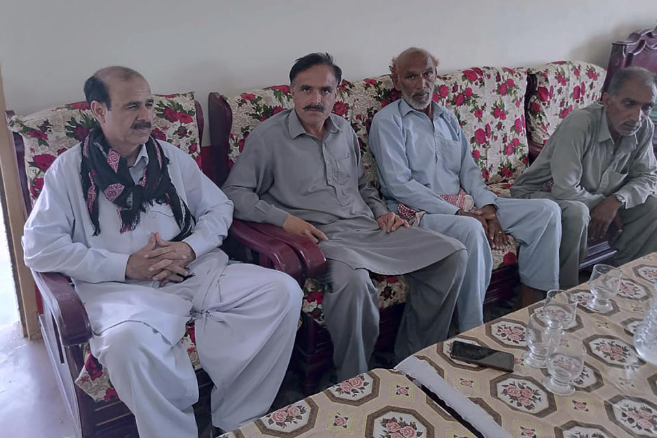 People offer their support to Raja Tariq, left, whose son Raja Awais is missing after a shipwreck off the Greek coast, in Bindian village in Kotli, a district of Pakistan's administrator Kashmir, Sunday, June 18, 2023. Pakistani Prime Minister Shehbaz Sharif declared a national day of mourning for citizens who died when the fishing trawler packed with migrants they were in sank off the Greek coast. (AP Photo/Nasir Mehmood)