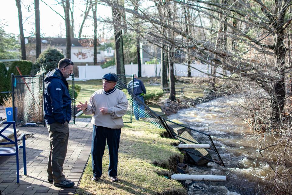 North Providence Mayor Charles Lombardi, right, talks to Eric Pelletier, a division supervisor for the Federal Emergency Management Agency, at a house on West River Parkway during a Jan. 13 tour of flooding near a stream that significantly eroded its banks.