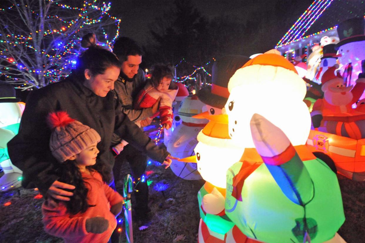 The Herrere family, of Hanson - from left, Valerie, 4, Caitlin, Ole, and Lucy, 1 - admire the decorations at the Holiday House of Hanson.