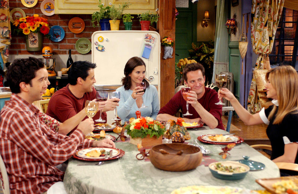 friends gathered around the table holding up their glasses