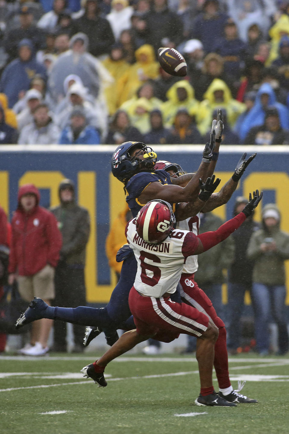 Oklahoma defensive backs Trey Morrison (6) and Woodi Washington (0) break up a pass intended for West Virginia wide receiver Bryce Ford-Wheaton (0) during the first half of an NCAA college football game in Morgantown, W.Va., Saturday, Nov. 12, 2022. (AP Photo/Kathleen Batten)