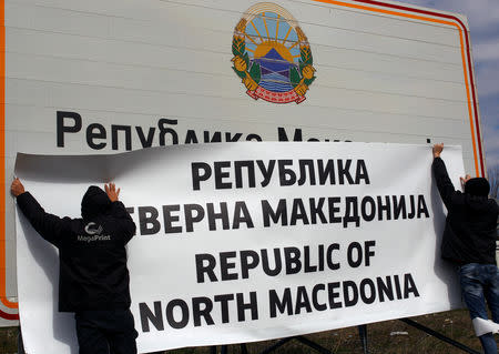 Workers set up a sign with Macedonia's new name at the border between Macedonia and Greece, near Gevgelija, Macedonia February 13, 2019. REUTERS/Ognen Teofilovski