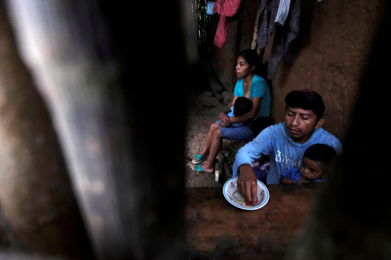 Jose Armando Suchite feeds his 22-months old son Carlos with a tortilla with salt and a cooked tomato, at their home, in La Palmilla