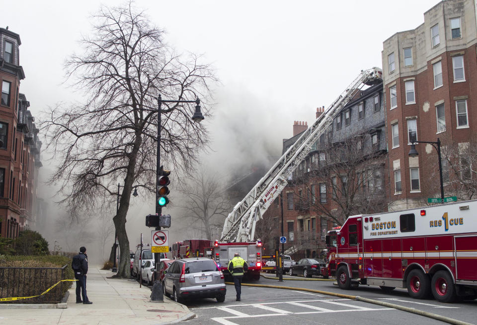 Firefighters fight a multi-alarm fire at a four-story brownstone in the Back Bay neighborhood near the Charles River, Wednesday, March 26, 2014, in Boston. Boston EMS spokesman Nick Martin says four people, including at least three firefighters, have been taken to hospitals. (AP Photo/Scott Eisen)