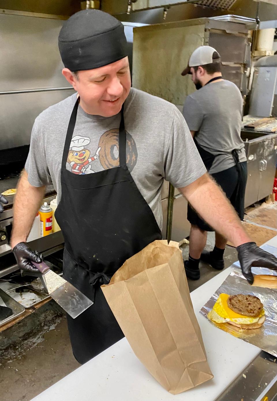 (From left) Bryan Thomas and George Barouxis prepare orders Jan. 6 at Buckeye Donuts.