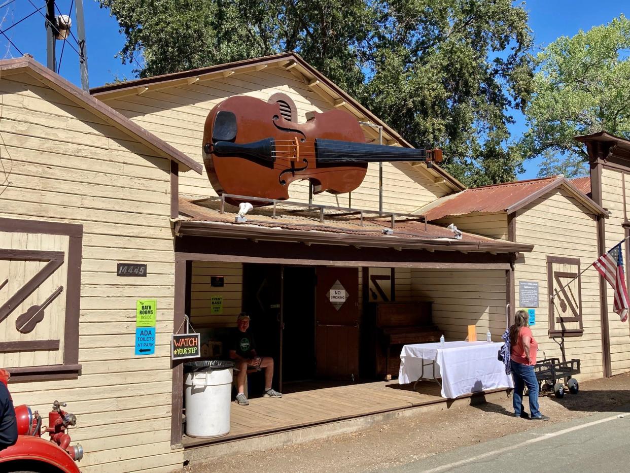 Fiddletown Community Center, built 1934 as a dance hall, features huge fiddle over the entrance.