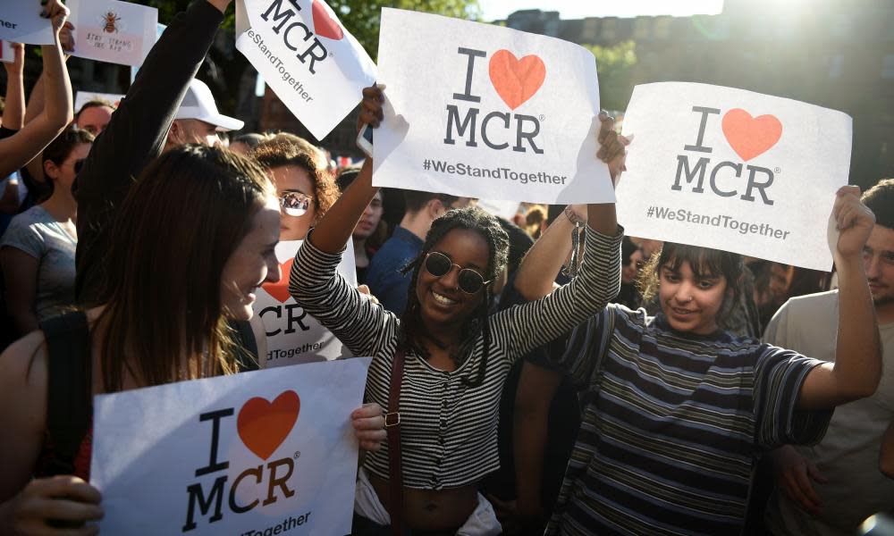 People hold ‘I love MCR’ banners during a vigil in Manchester on Tuesday.