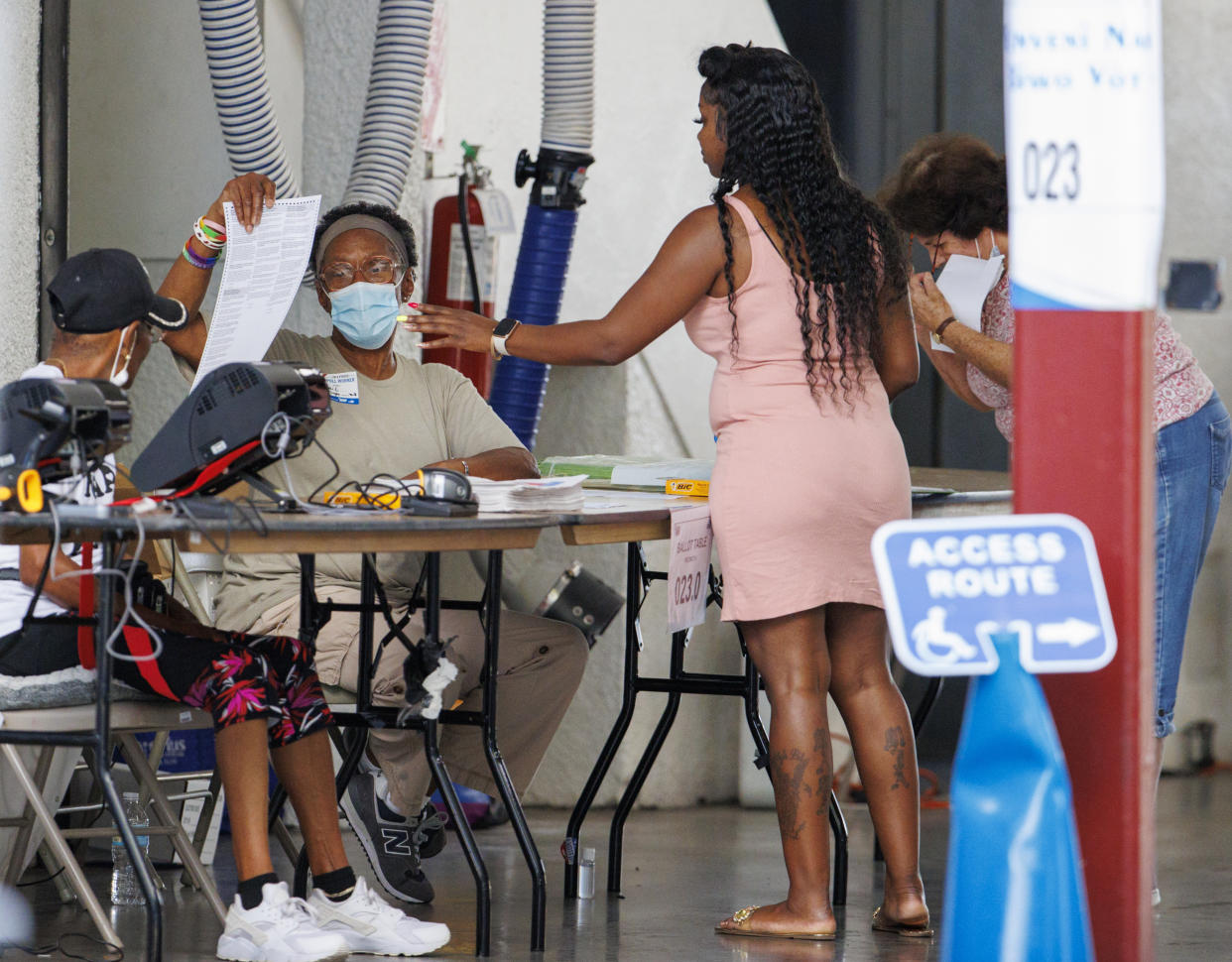 Polling workers assisting a voters during the Florida primary election at the Miami Beach Fire Department - Station 3 on Tuesday, Aug. 23, 2022 in Miami Beach, Fla. (David Santiago /Miami Herald via AP)