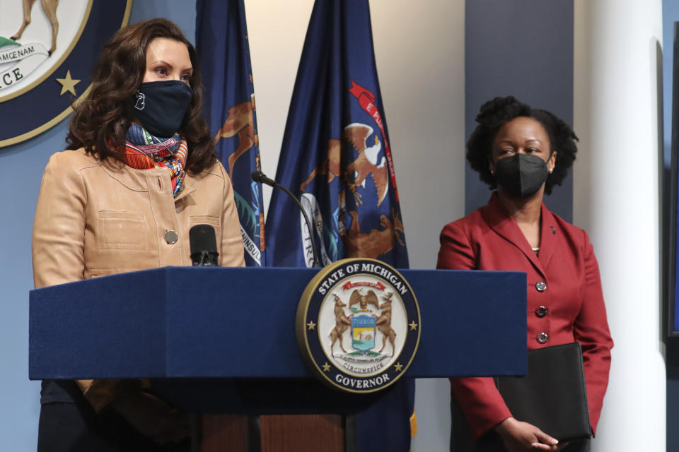 In this photo provided by the Michigan Office of the Governor, Gov. Gretchen Whitmer addresses the state as Michigan Department of Health and Human Services Chief Medical Executive Dr. Joneigh Khaldun, right, listens in on Friday, April 9, 2021, in Lansing, Mich. Faced with the country's highest rate of new coronavirus infections, Whitmer on Friday urged a two-week suspension of in-person high school classes, all youth sports and indoor restaurant dining. (Michigan Office of the Governor via AP)