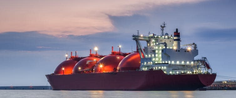 A large tanker vessel with red, bulbous tanks for LNG.