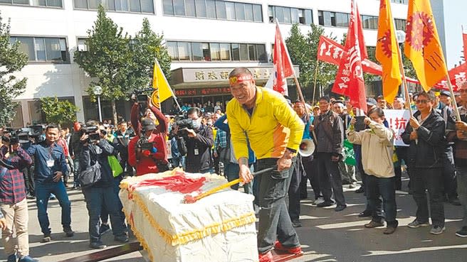 台中港碼頭工人抗議公用碼頭變更為專用，直指棺材本不保，怒持斧頭劈棺。（陳淑娥攝）