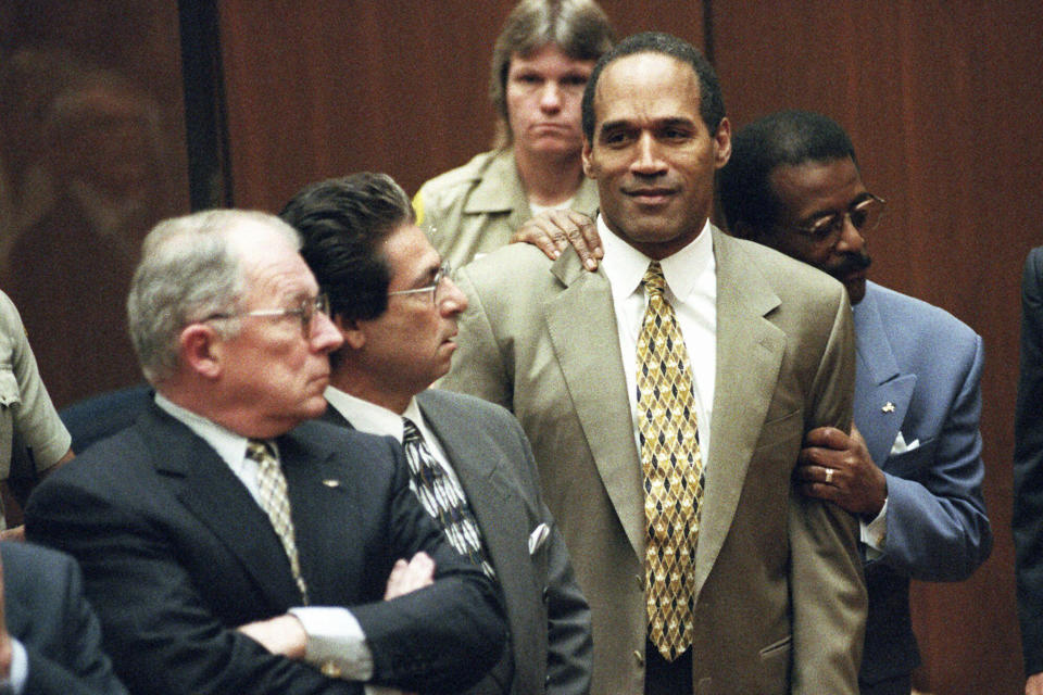 ARCHIVO - En esta fotografía de archivo del 3 de octubre de 1995, el abogado Johnnie Cochran Jr. sostiene a O.J. Simpson mientras se lee el veredicto de no culpabilidad en una sala del tribunal de Los Ángeles durante su juicio en Los Ángeles. Los abogados defensores F. Lee Bailey, izquierda, y Robert Kardashian miran. O.J. Simpson, el laureado astro del fútbol americano y actor de Hollywood que fue absuelto de los cargos de doble asesinato de su exesposa y su amigo, pero luego declarado responsable en un juicio civil aparte, ha fallecido. Tenía 76 años. (Myung J. Chun/Los Angeles Daily News via AP, Pool, archivo)