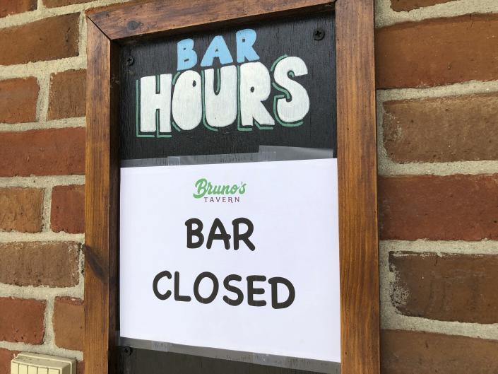 A sign hangs outside Bruno’s Tavern in New Orleans on Tuesday, July 14, 2020. Bruno’s is one of many bars around the city that shut down under new restrictions the state announced over the weekend to fight the spread of coronavirus. Bars in New Orleans had been allowed to open, with limited capacity, a month earlier when the number of hospitalizations from the virus in Louisiana was in decline. (AP Photo/Kevin McGill)
