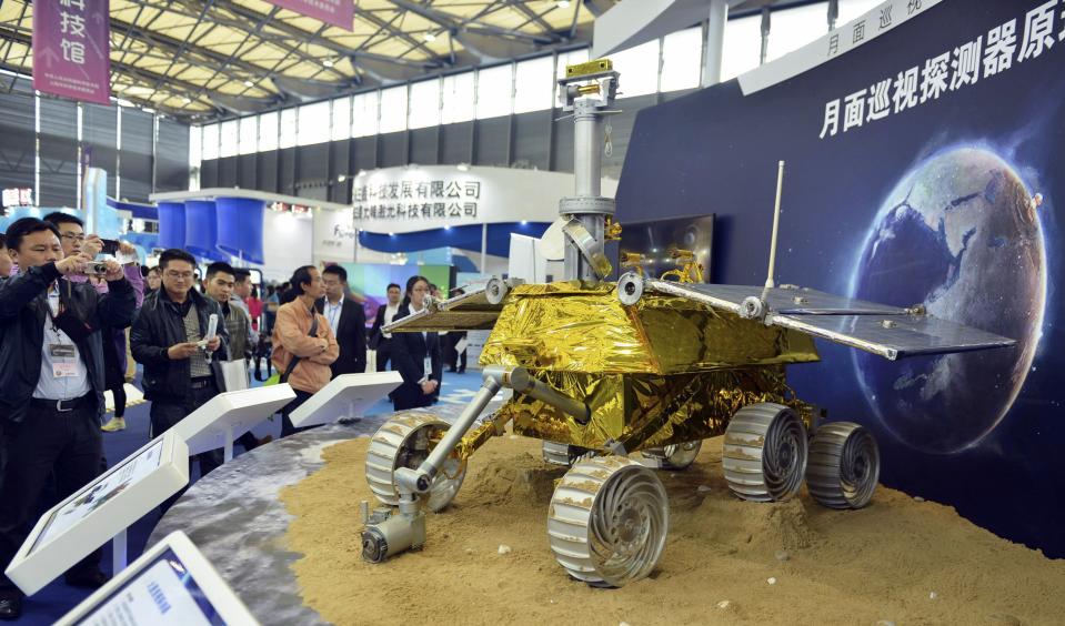 Visitors take pictures of a prototype model of a lunar rover at the 15th China International Industry Fair in Shanghai