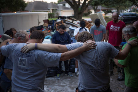 Samaritans pray after helping clear furniture from the flooded house of a neighbor in the aftermath of Tropical Storm Harvey in Houston, Texas, U.S. September 3, 2017. REUTERS/Adrees Latif