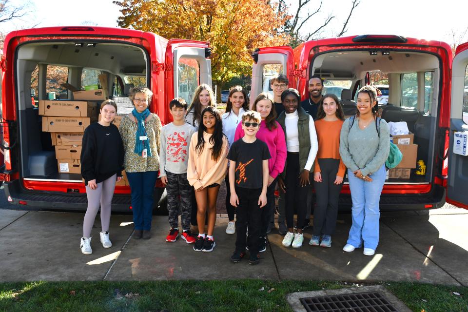 Students and chaperones from Sewickley Academy stand in front of vans packed full of food collected for those in need during their "Spirit of Community" event on Nov. 15, 2023.