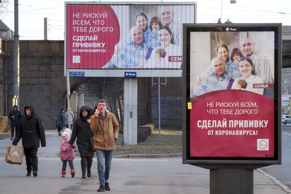 People walk past posters reading "Do not risk everything that is dear to you. Get vaccinated against coronavirus" in St. Petersburg, Russia, Saturday, April 3, 2021. Russia has boasted about being the first country in the world to authorize a coronavirus vaccine and rushed to roll it out earlier than other countries, even as large-scale testing necessary to ensure its safety and effectiveness was still ongoing. (AP Photo/Dmitri Lovetsky)