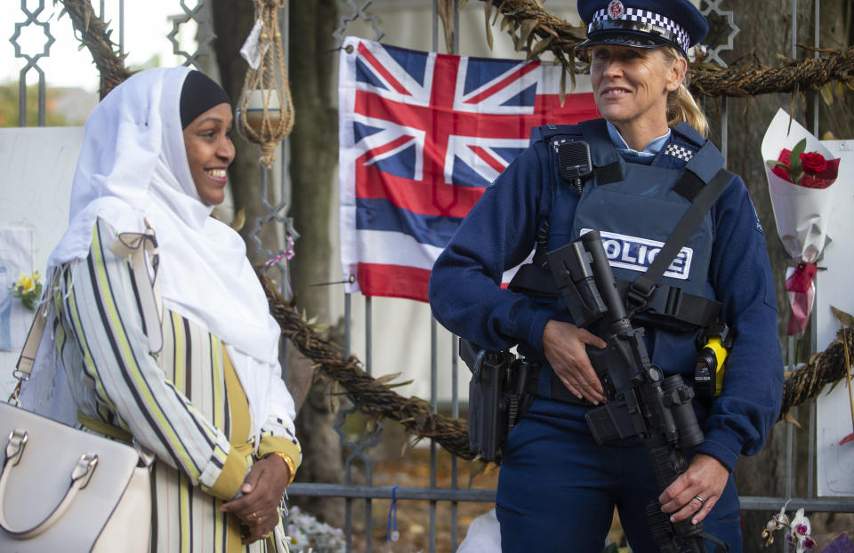 A woman walks past an armed police officer at the Al Noor mosque during a visit to the mosque in Christchurch, New Zealand, Friday, April 26, 2019. Britain's Prince William visited the one of the mosques where 50 people were killed and 50 others wounded in a March 15 attack by a white supremacist. (Joseph Johnson/Pool Photo via AP)