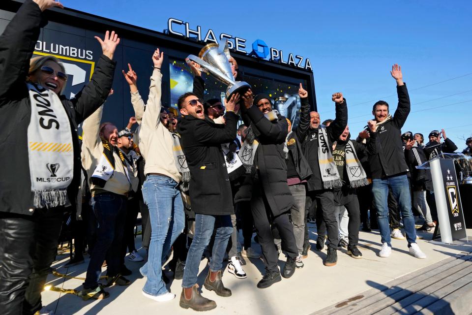 Tim Bezbatchenko (left) and Crew head coach Wilfried Nancy hold up the Philip F. Anschutz Trophy as they celebrate their 2023 MLS Cup victory outside of Lower.com Field.