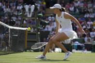 Poland's Iga Swiatek returns the ball to France's Alize Cornet during a third round women's singles match on day six of the Wimbledon tennis championships in London, Saturday, July 2, 2022. (AP Photo/Kirsty Wigglesworth)