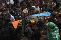 Palestinian mourners, some armed, carry the body of Amjad al-Fayyed, 17, during his funeral in the West Bank refugee camp of Jenin, Saturday, May 21, 2022. Israeli troops shot and killed al-Fayyed as fighting erupted when soldiers entered a volatile town in the occupied West Bank early Saturday, the Palestinian health ministry and local media said. (AP Photo/Majdi Mohammed)