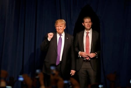 Republican U.S. presidential candidate Donald Trump pumps his fist as he arrives arrives with his son Eric (R) to address supporters after being declared by the television networks as the winner of the Nevada Repulican caucuses at his caucus night rally in Las Vegas, Nevada, February 23, 2016. REUTERS/Jim Young