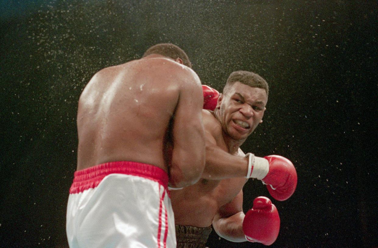 1988-Atlantic City, NJ Ferocious faced Mike Tyson lands the knockout punch to the jaw of challenger Larry Holmes during fourth round of the World Heavyweight Championship.