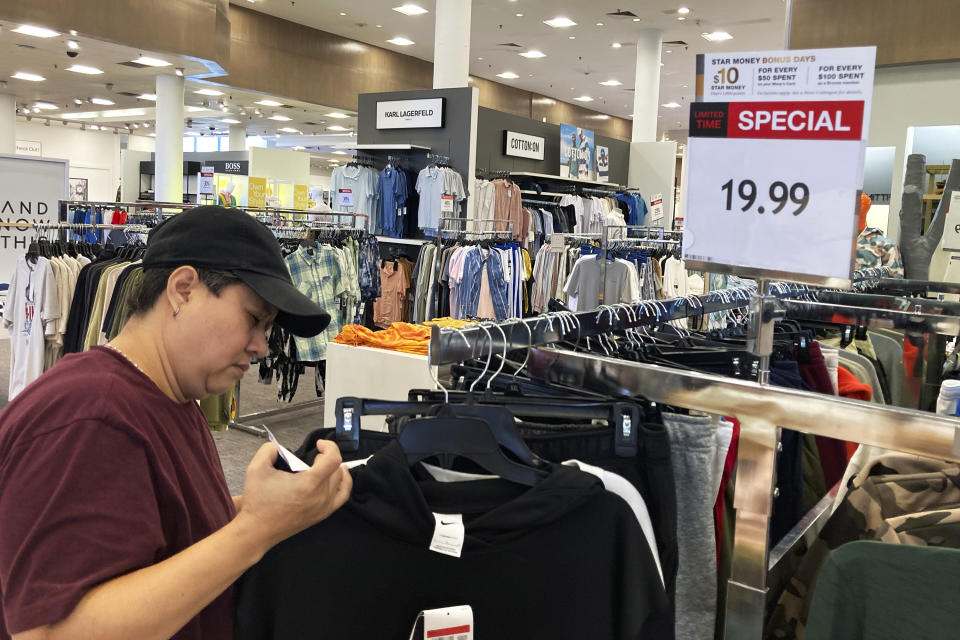 FILE - A customer checks price tags while shopping at a retail store in Schaumburg, Ill., Thursday, June 30, 2022. Consumers picked up their spending in June from May despite surging prices in gas and food. U.S. retail sales rose 1% last month, from a revised decline of 0.1 % in May, the Commerce Department said Friday, July 15, 2022. (AP Photo/Nam Y. Huh, File)