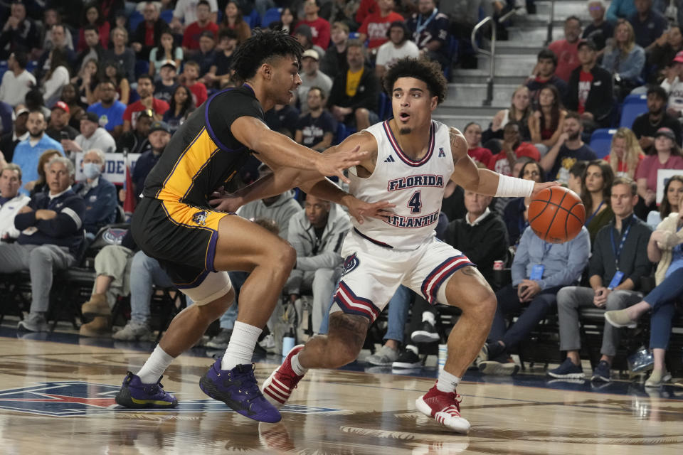 East Carolina guard Quentin Diboundje (7) defends Florida Atlantic guard Bryan Greenlee (4) during the first half of an NCAA college basketball game, Tuesday, Jan. 2, 2024, in Boca Raton, Fla. (AP Photo/Marta Lavandier)