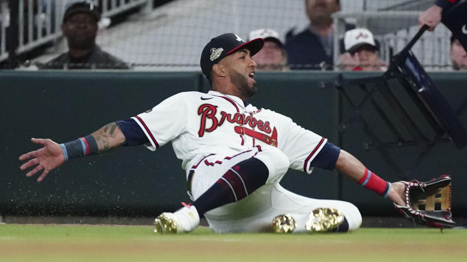 Atlanta Braves left fielder Eddie Rosario (8) dives for the ball but misses on a hit by Cincinnati Reds' Aristides Aquino (44) during a baseball game Thursday, April 7, 2022, in Atlanta. (AP Photo/John Bazemore)