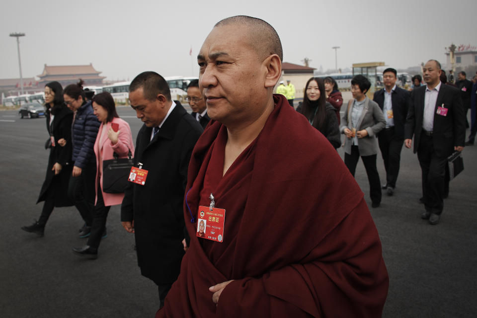 A Tibetan monk, a delegate to the Chinese People's Political Consultative Conference (CPPCC), arrives with other delegates to the Great Hall of the People to attend a plenary session of the CPPCC in Beijing, Sunday, March 10, 2019. China is defending its often-criticized policies toward Tibet 60 years after the Dalai Lama fled abroad amid an uprising against Chinese rule. The official Xinhua News Agency says economic growth, increases in lifespan and better education refute the claims of critics. (AP Photo/Andy Wong)