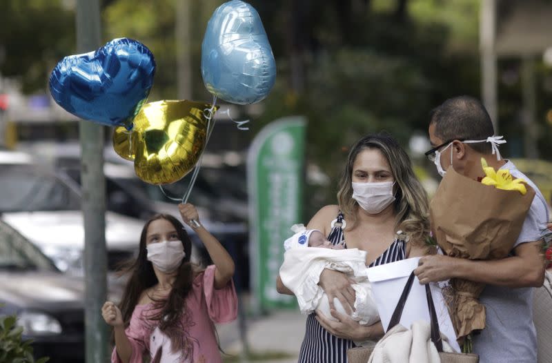 Rusia Goes, una enfermera que dio a luz el 26 de abril conectada a un tubo de ventilación que la ayudaba a respirar mientras luchaba contra los graves síntomas de COVID-19, sostiene en sus brazos a su hija Luisa, su bebé de nacimiento prematuro, junto a su hija mayor Julia y su esposo Ednaldo Goes al ser dada de alta del hospital, durante el brote de la enfermedad por coronavirus (COVID-19) en Río de Janeiro, Brasil